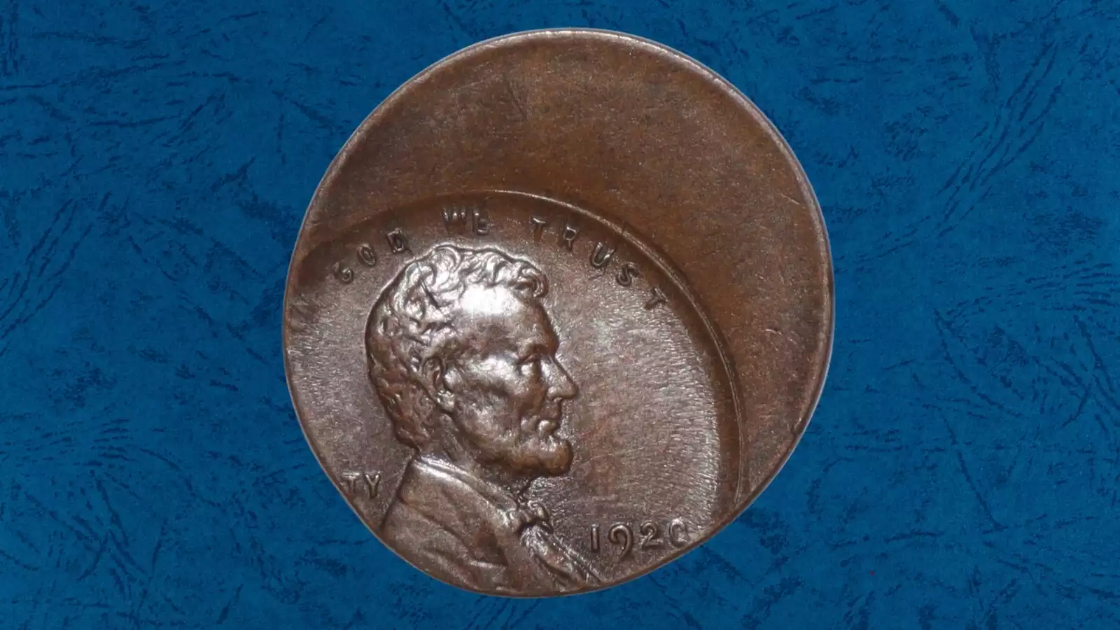 1920 wheat penny with off-center strike error showing the design shifted approximately 25 percent with a blank crescent of copper planchet visible